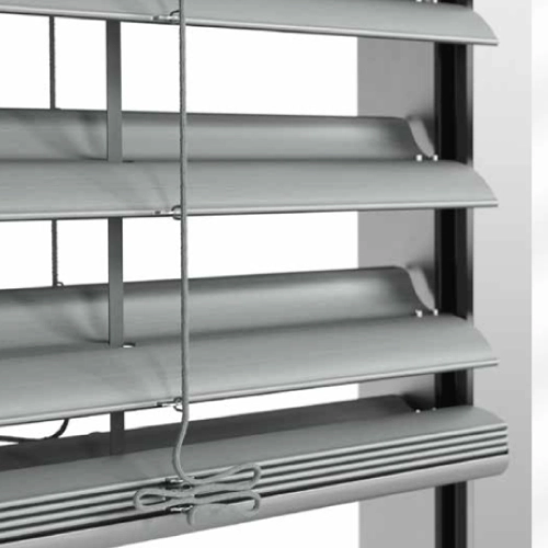 Vue rapprochée de lames métalliques inclinées d'un store vénitien, permettant de contrôler la lumière et la ventilation à travers une fenêtre moderne.